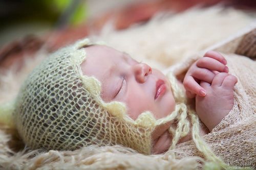 צלמת ניו בורן במרכז- תינוק מתוק עם כובע סרוג צהוב