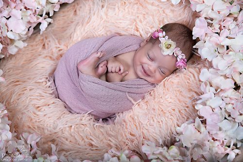 צילומי ניובורן בסגנון רומנטי תינוקת מחייכת