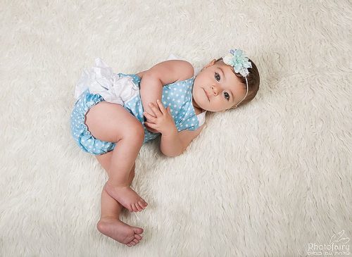 צילום תינוקות בגיל חצי שנה תינוקות שוכבת על שטיח לבן